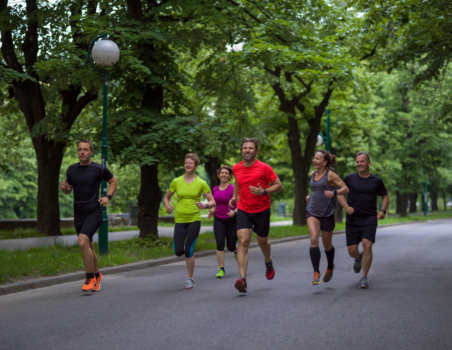group of healthy people jogging in city park, runners team on morning training
